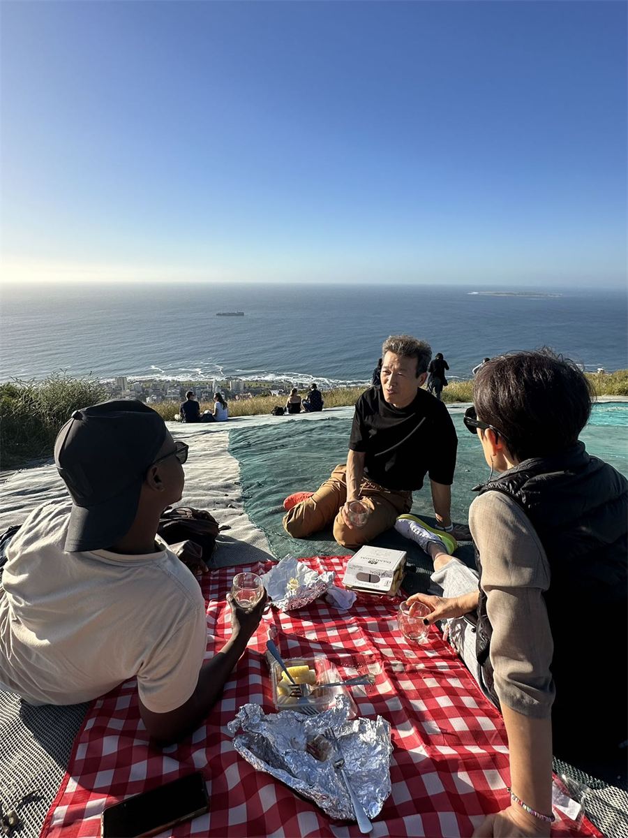 A picnic on a red checked blanket overlooking the ocean