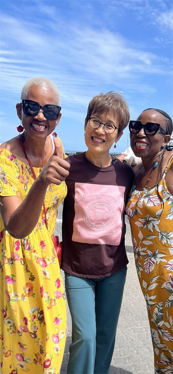 Three friends smiling together in the sunshine
